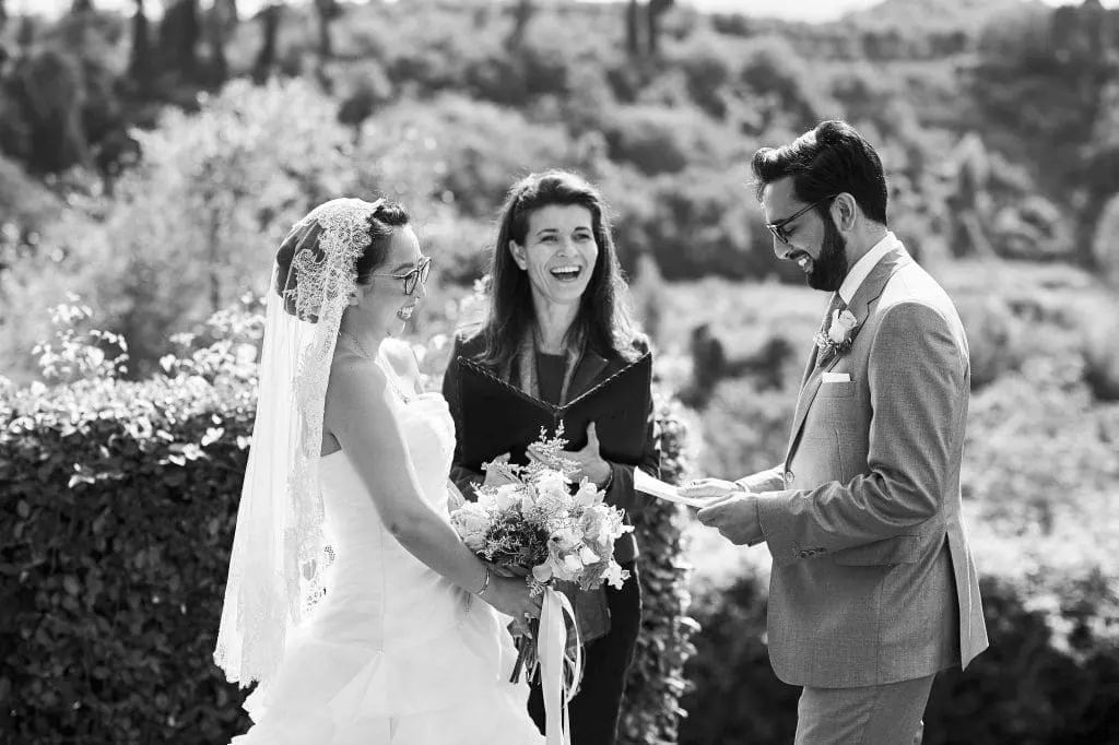 Black and white photo of a bilingual wedding ceremony in Tuscany, the couple exchanging vows