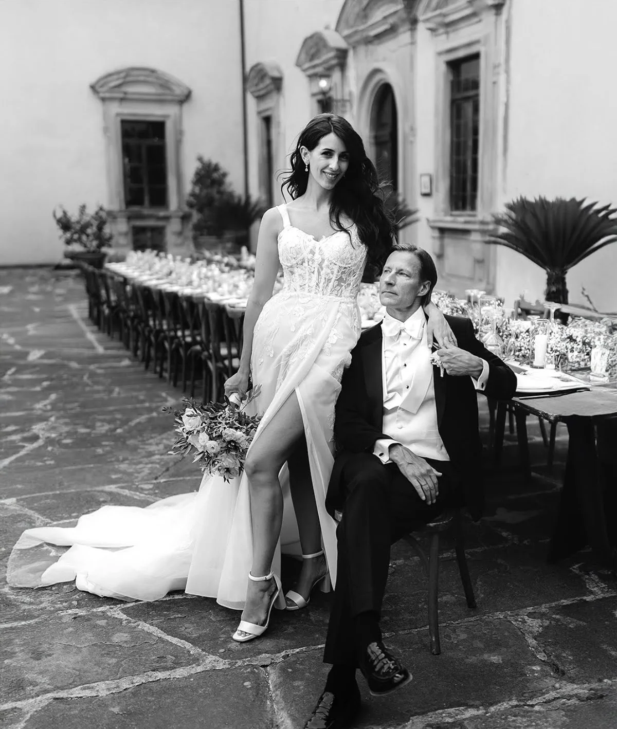 Every couple's paperwork Black and white portrait of bride and groom by the wedding table in a villa courtyard