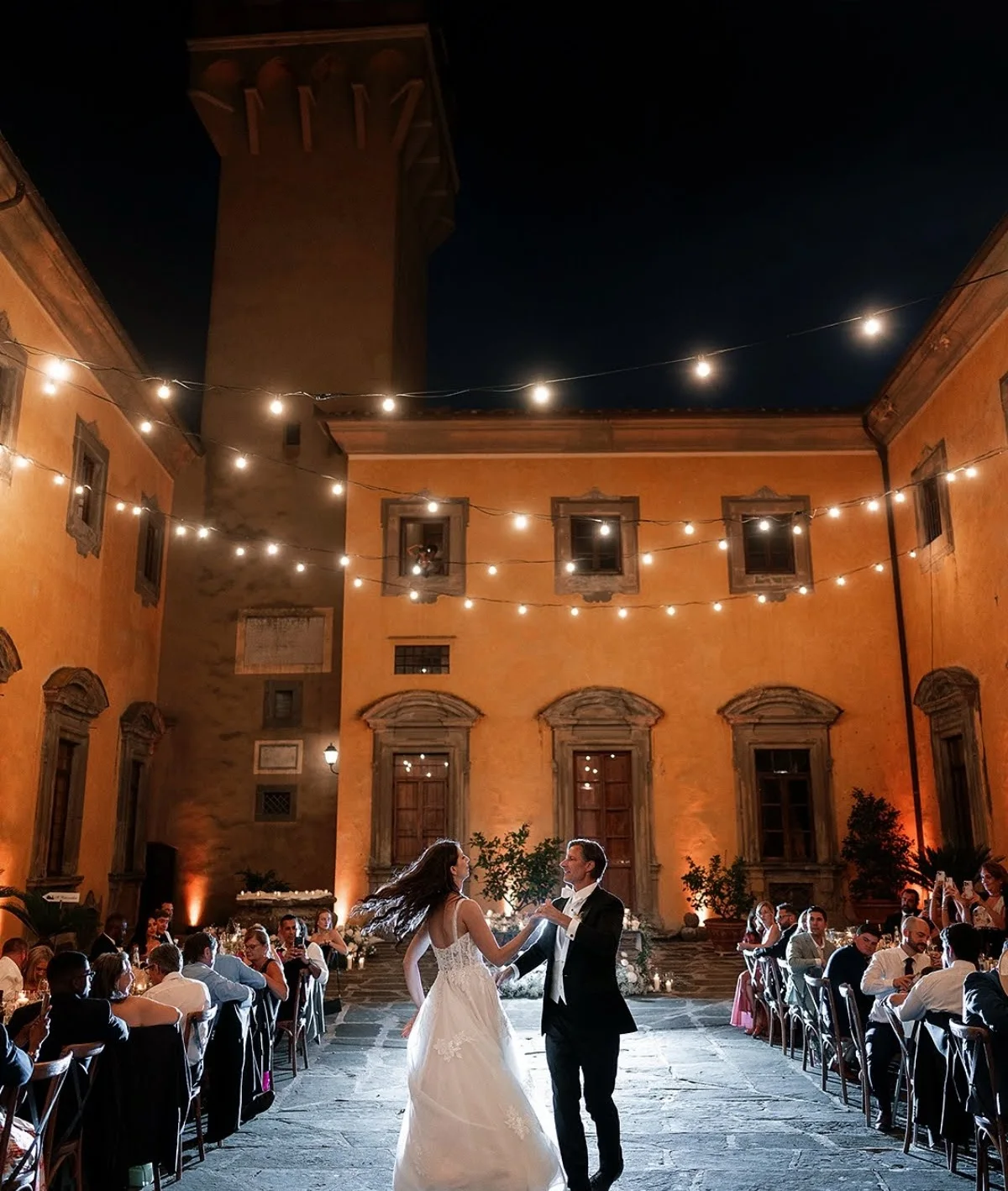 Primo ballo nel cortile di una villa sotto le lucine, di sera