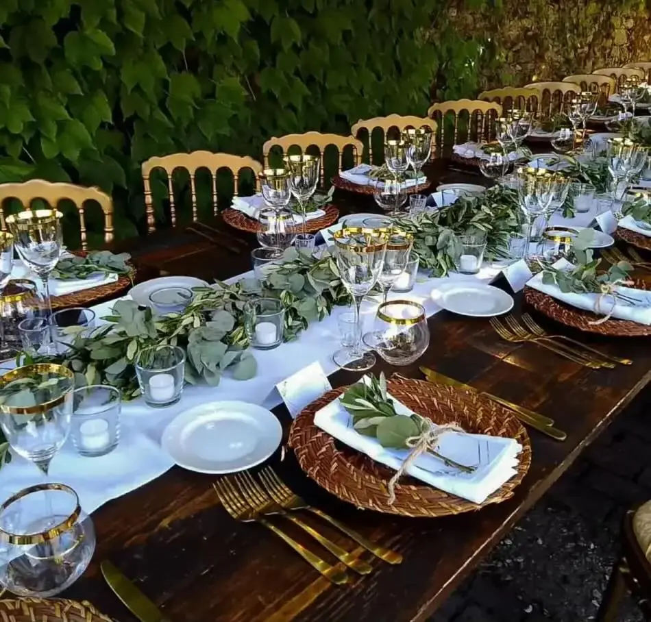 Tavola di matrimonio con bicchieri dal bordo dorato e foglie di ulivo