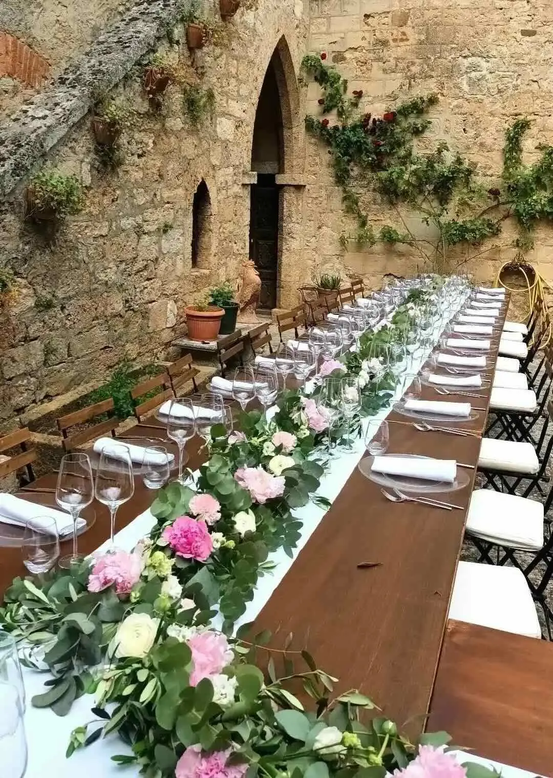 Luxury weddings Long wedding table with peonies in a medieval castle courtyard